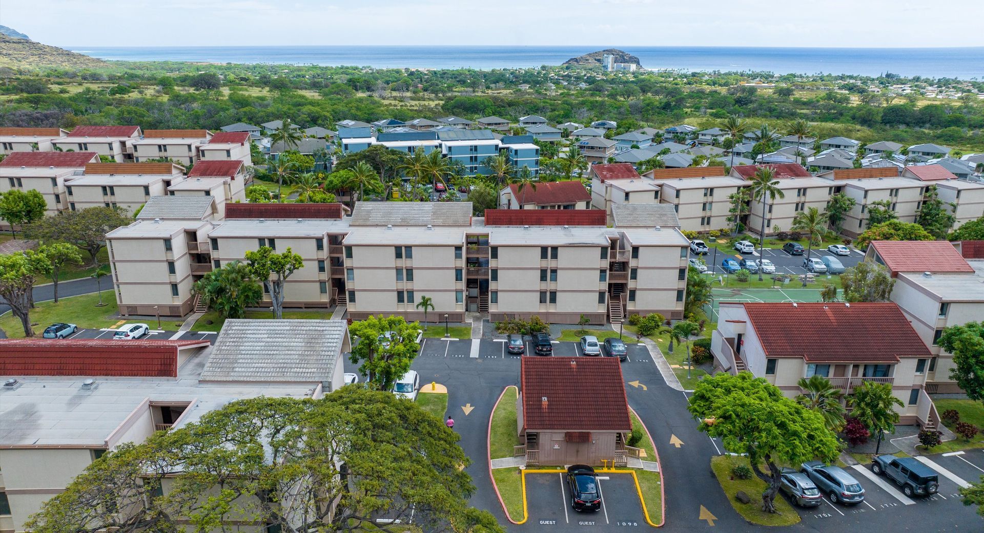 An aerial view of a residential area with lots of buildings and cars parked in front of them.