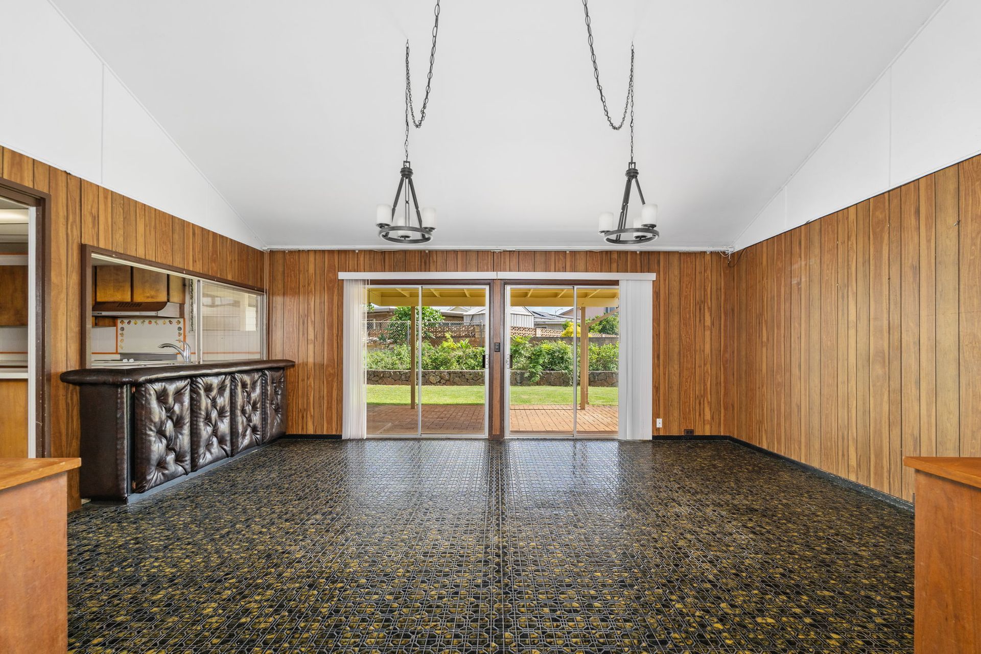 A large empty room with wood paneling and a marble floor.