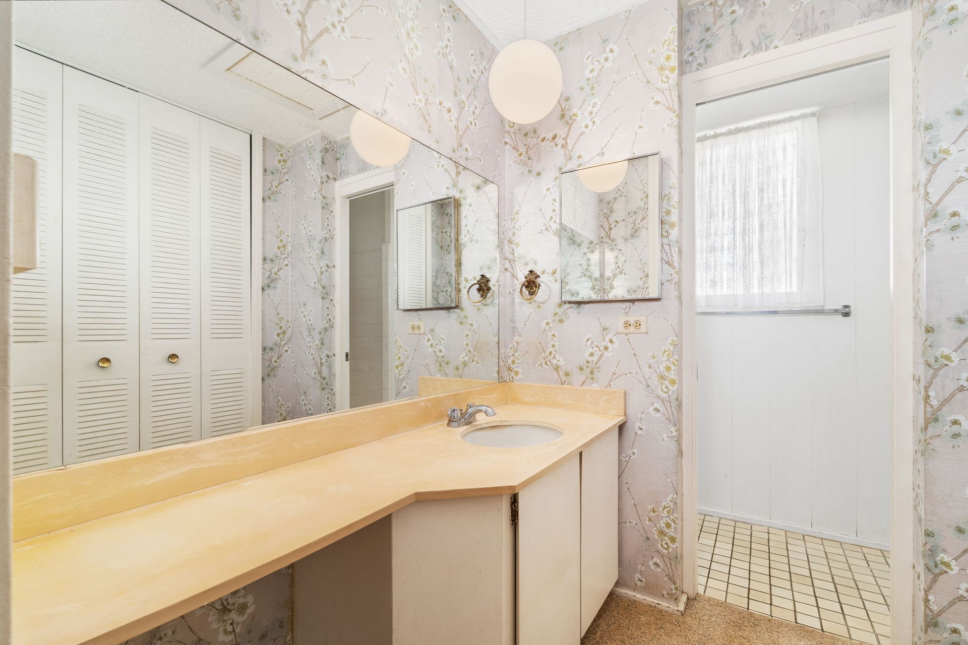 A bathroom with a sink , mirrors , and a walk in shower.