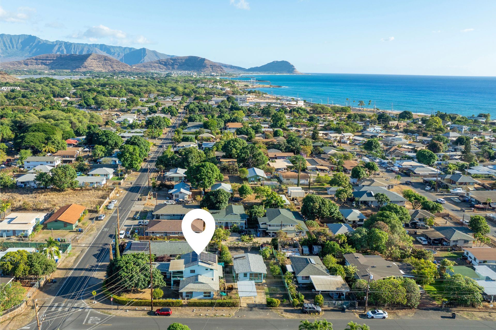 An aerial view of a residential area with a pin pointing the location of a house.