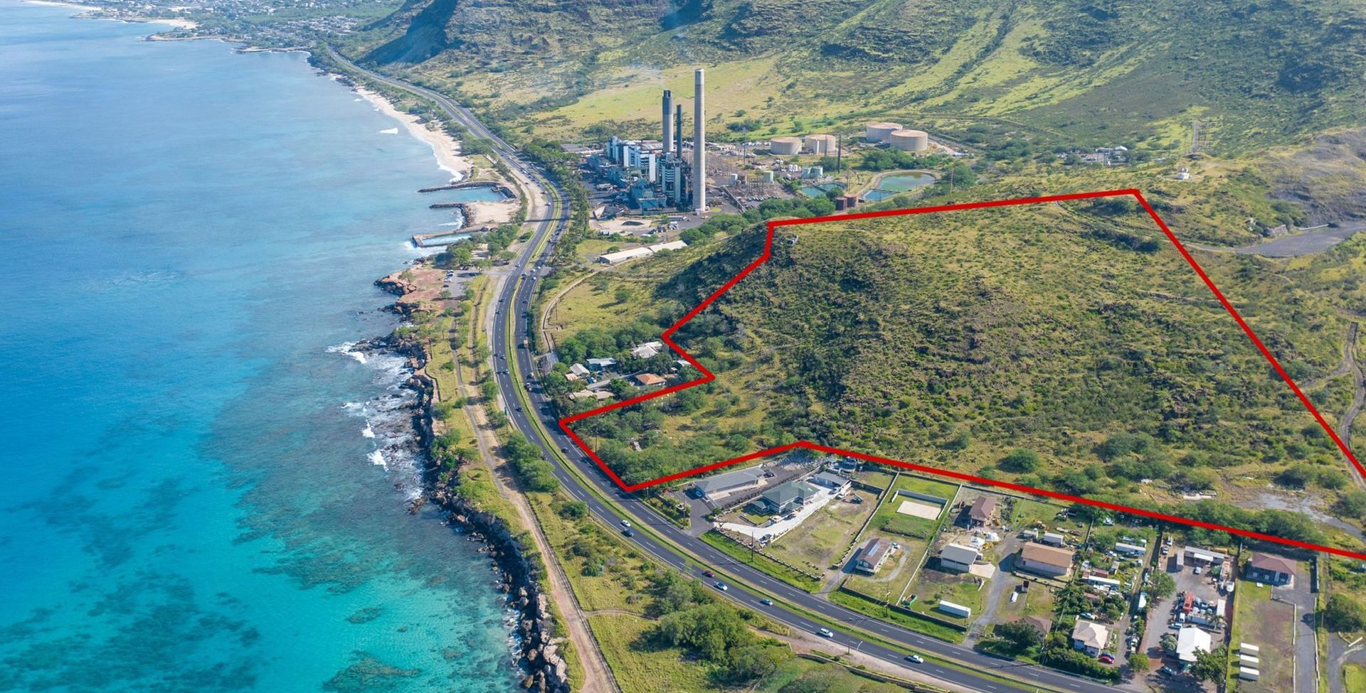 An aerial view of a lush green hillside next to a body of water.