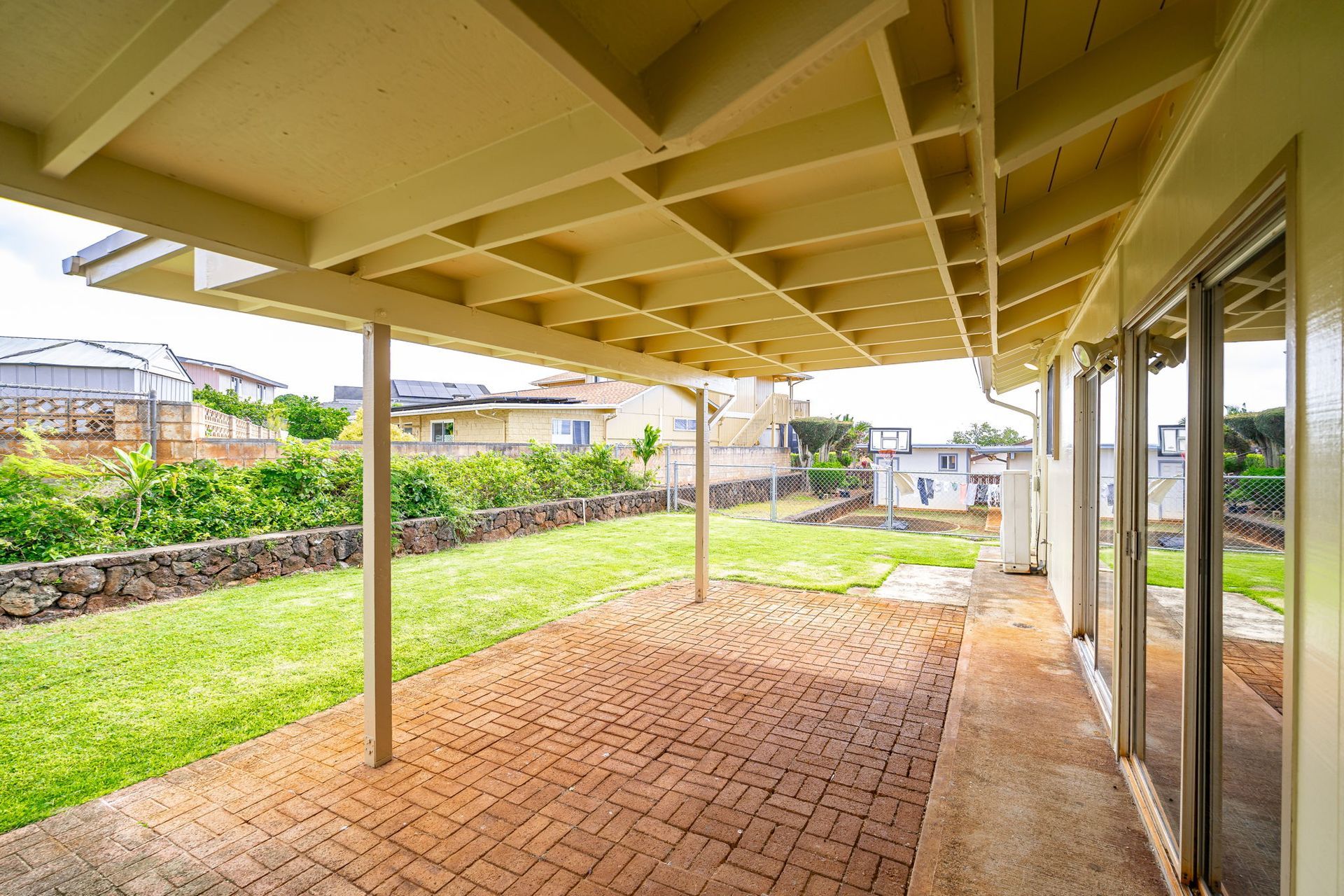 There is a covered patio with a brick floor and a roof.
