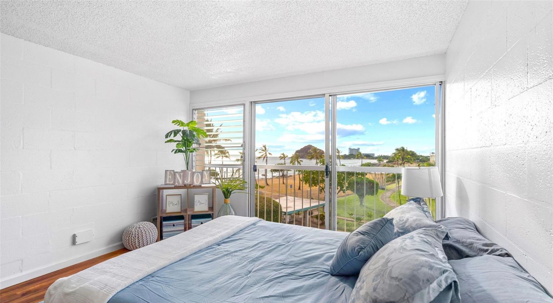 A bedroom with a large bed and sliding glass doors.