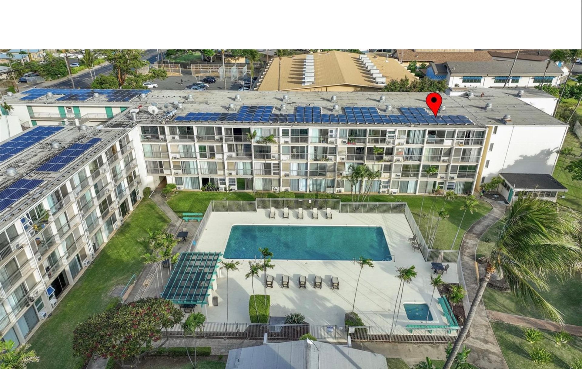 An aerial view of a building with a swimming pool in front of it