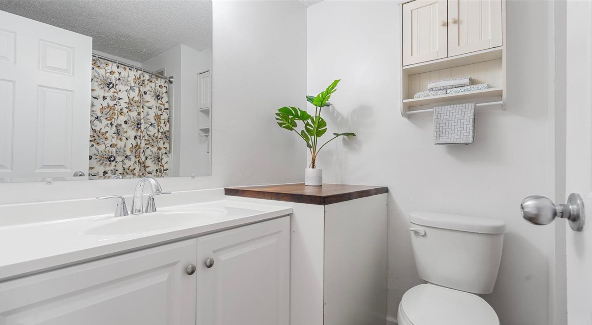 A bathroom with a toilet , sink , and mirror.