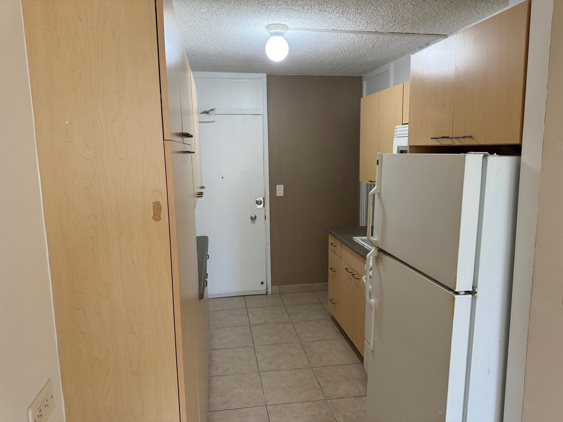 A kitchen with a refrigerator and a door