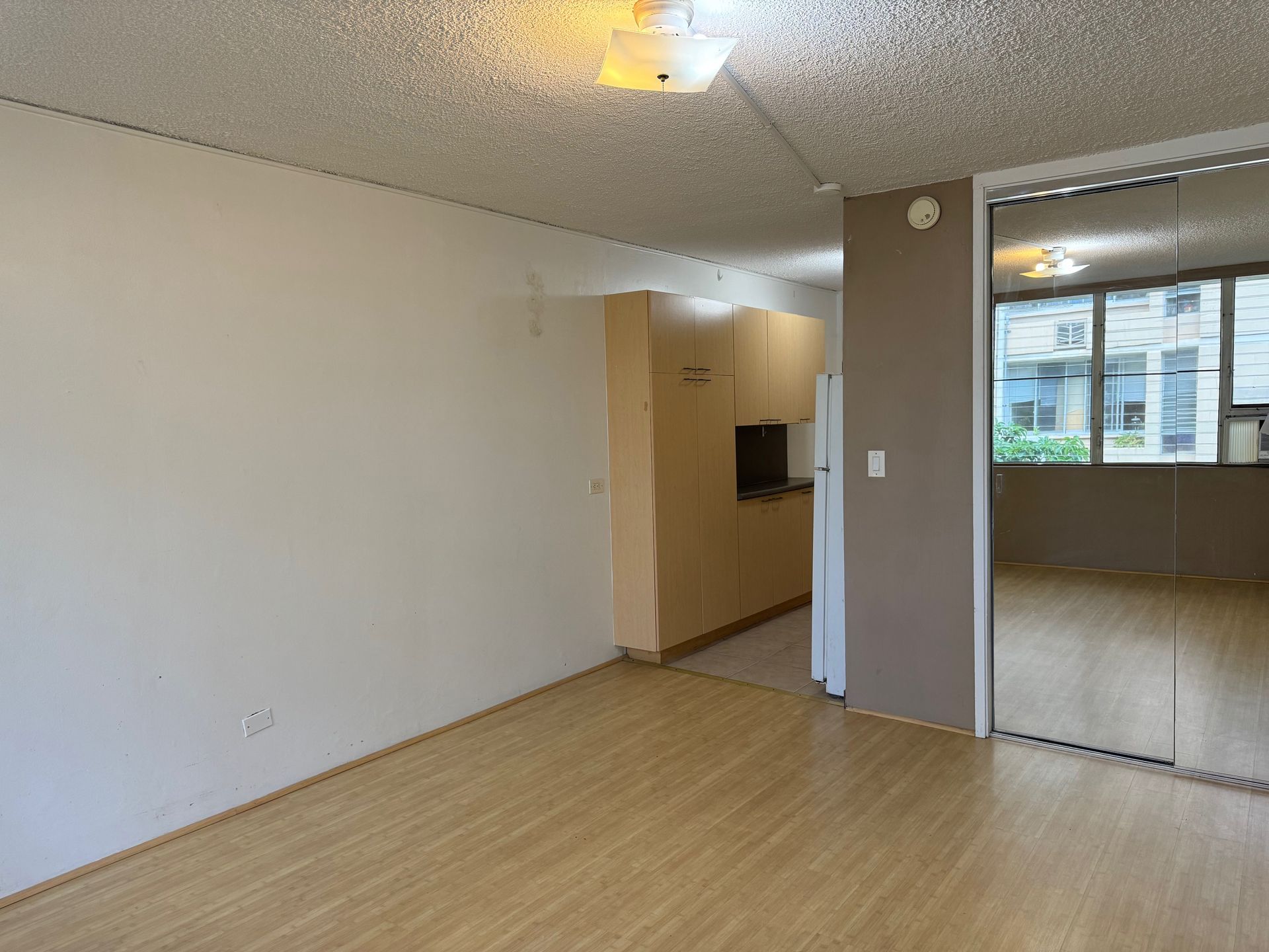 An empty living room with hardwood floors and white walls.