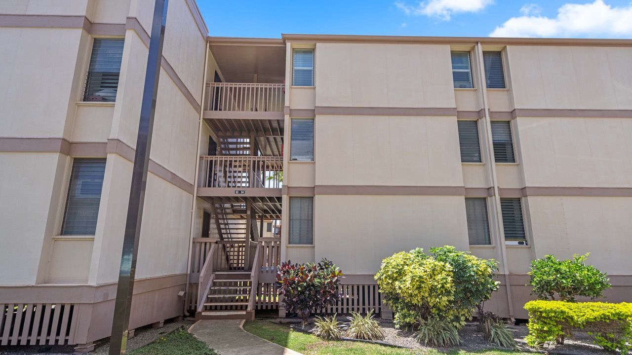 A large apartment building with stairs leading up to the second floor