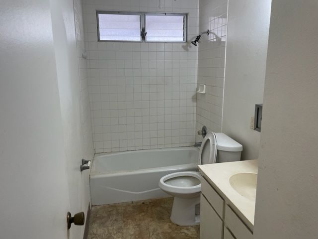 A bathroom with a toilet a sink and a bathtub