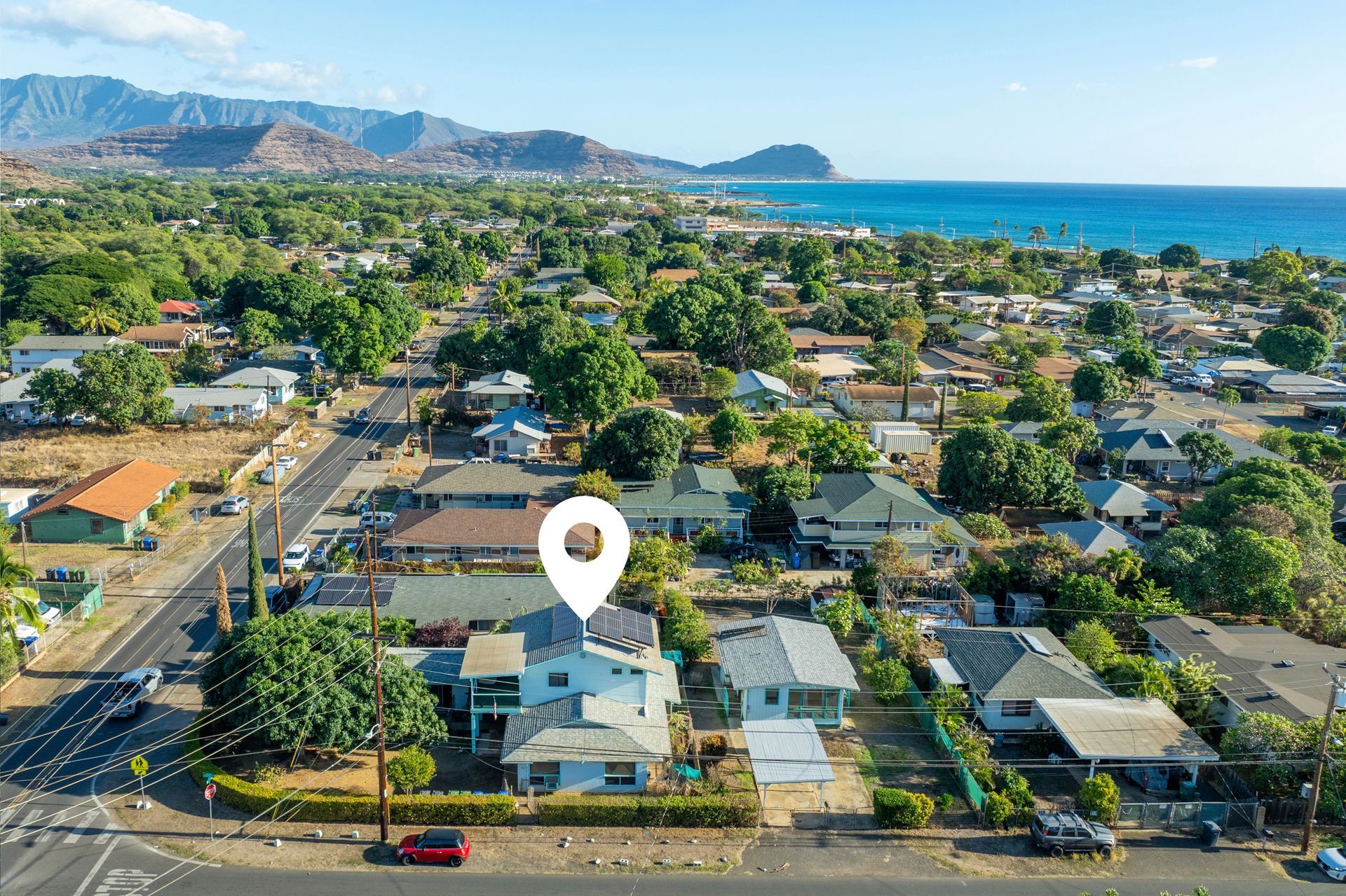 An aerial view of a residential area with a pin pointing the location of a house.