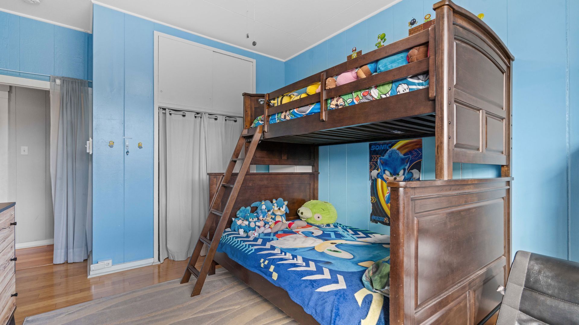 A bunk bed with a ladder in a bedroom with blue walls.