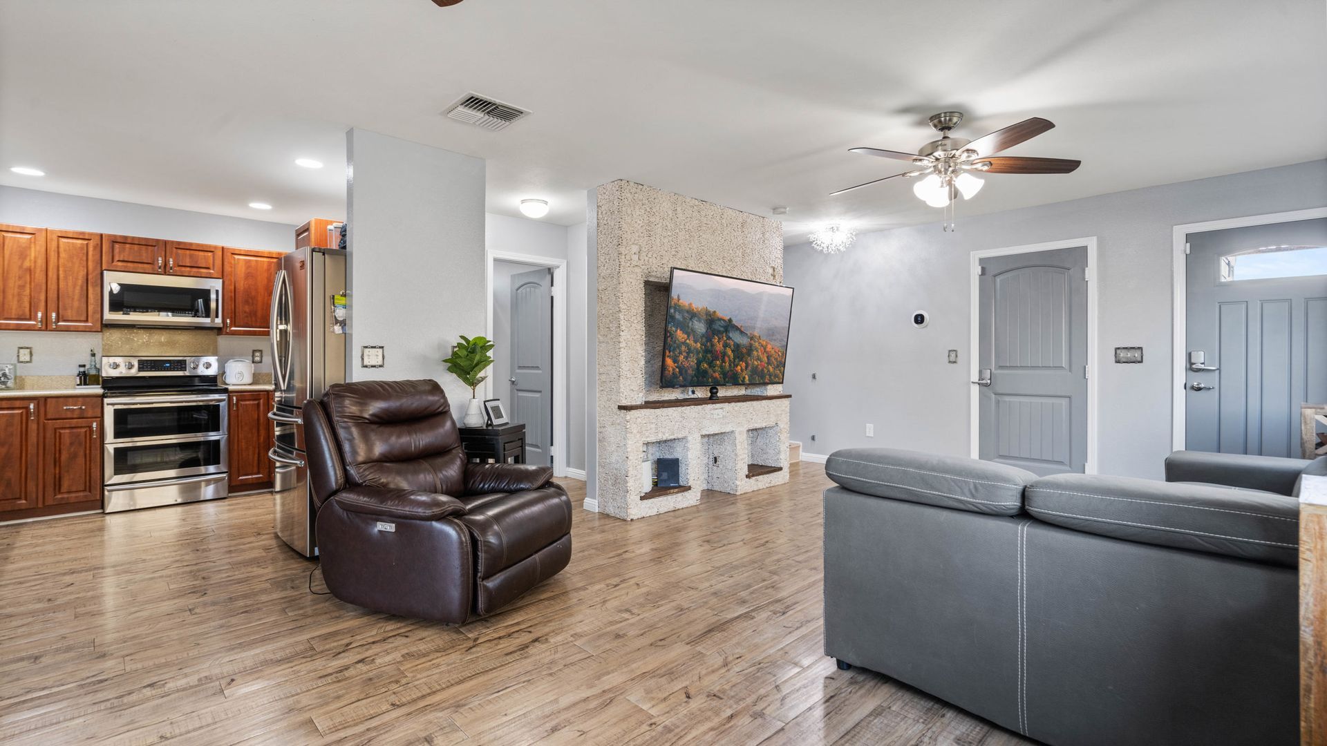 A living room with a couch , chair , and ceiling fan.