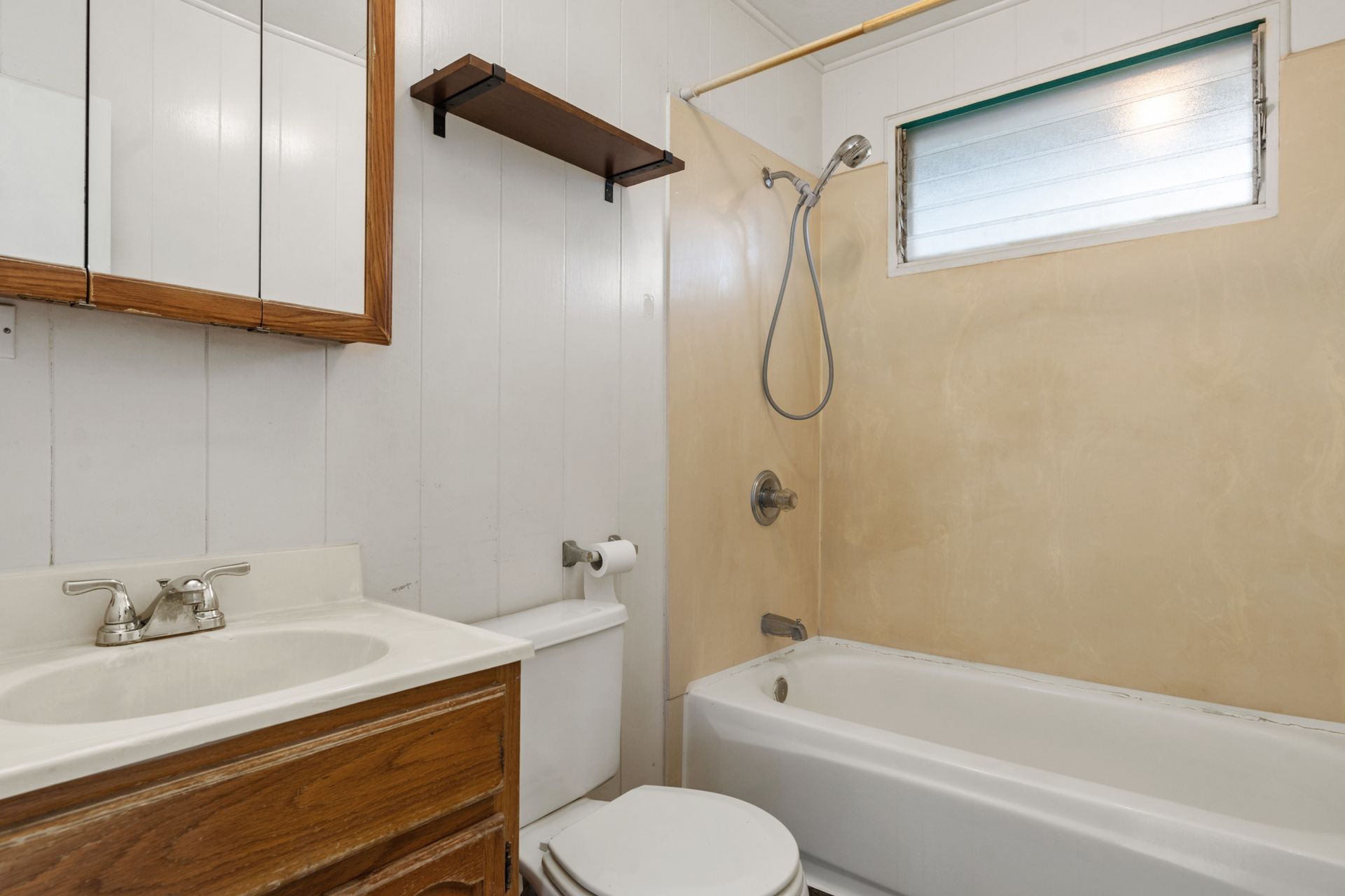 A bathroom with a toilet , sink and bathtub.
