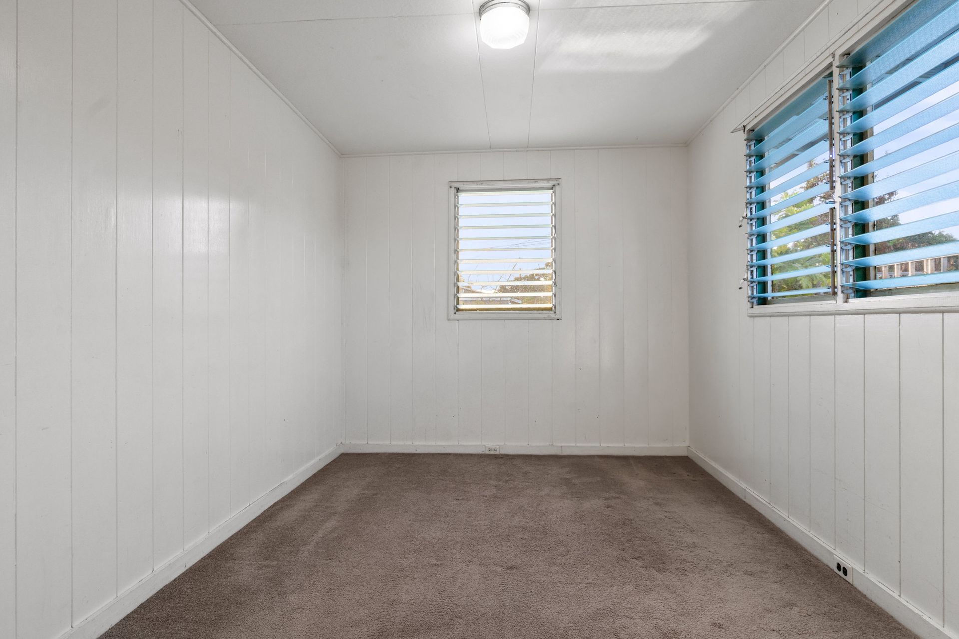 An empty room with white walls and a window.