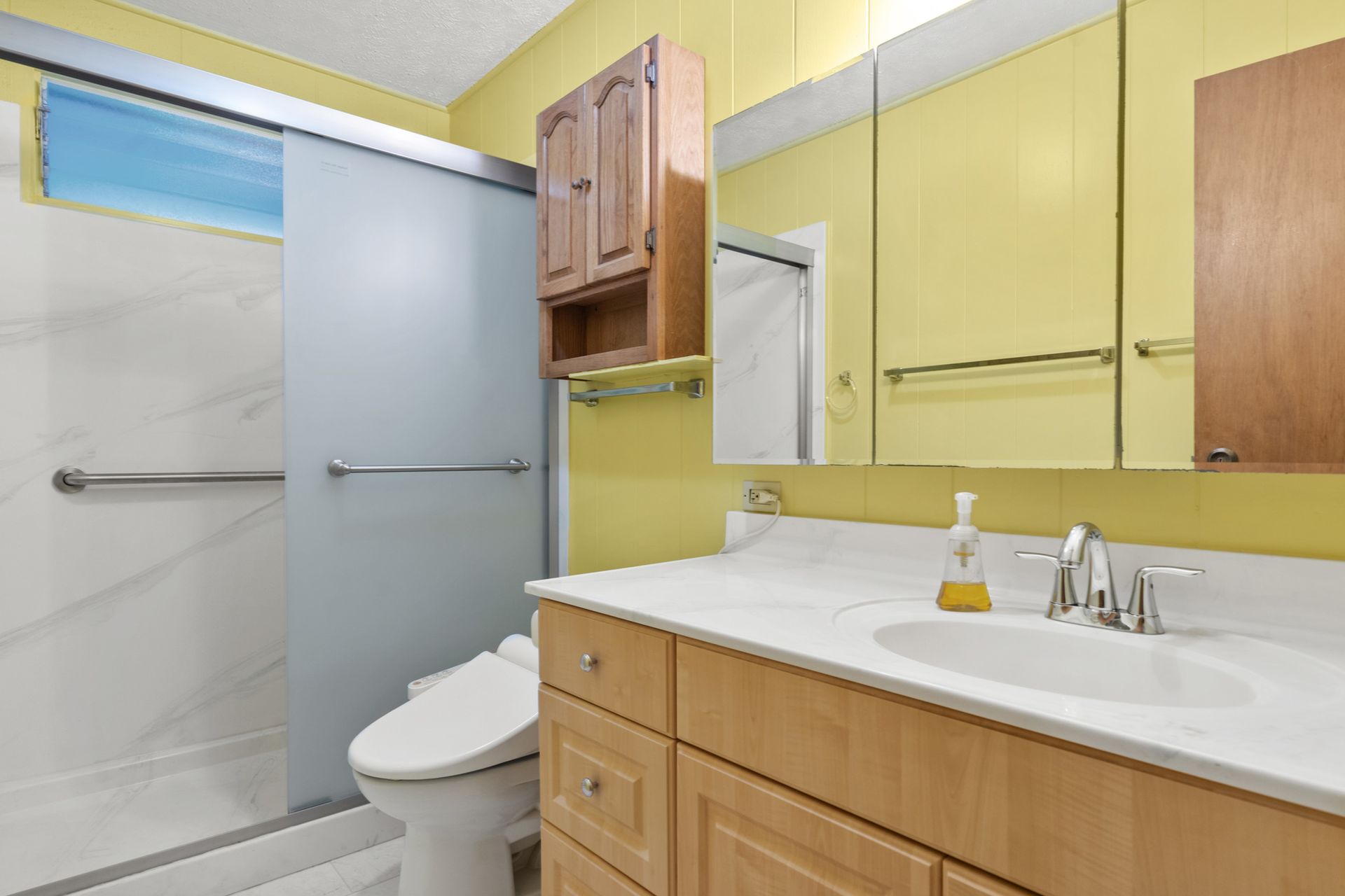 A bathroom with a sink , toilet and shower.