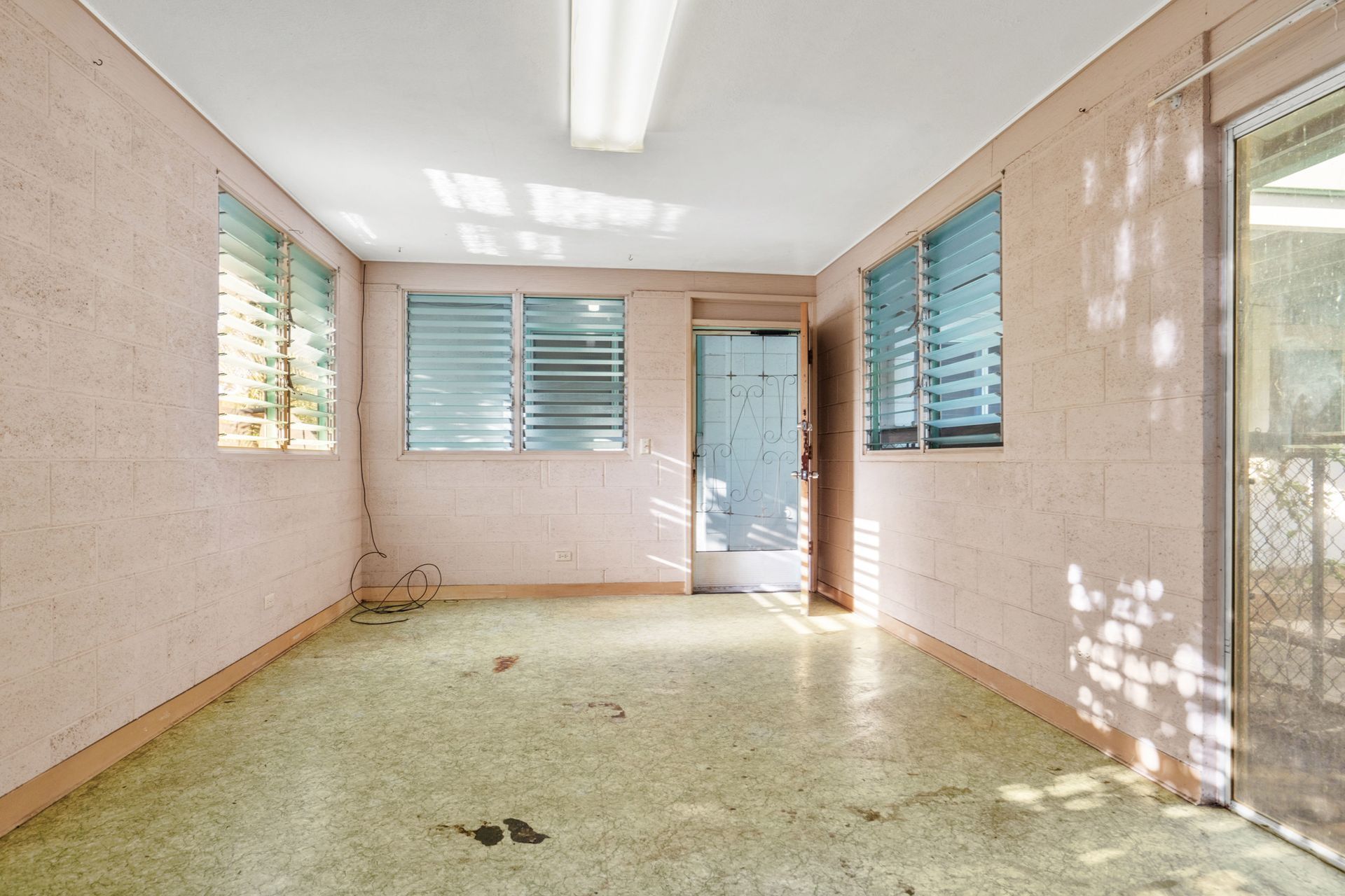 An empty room with a sliding glass door and a lot of windows.