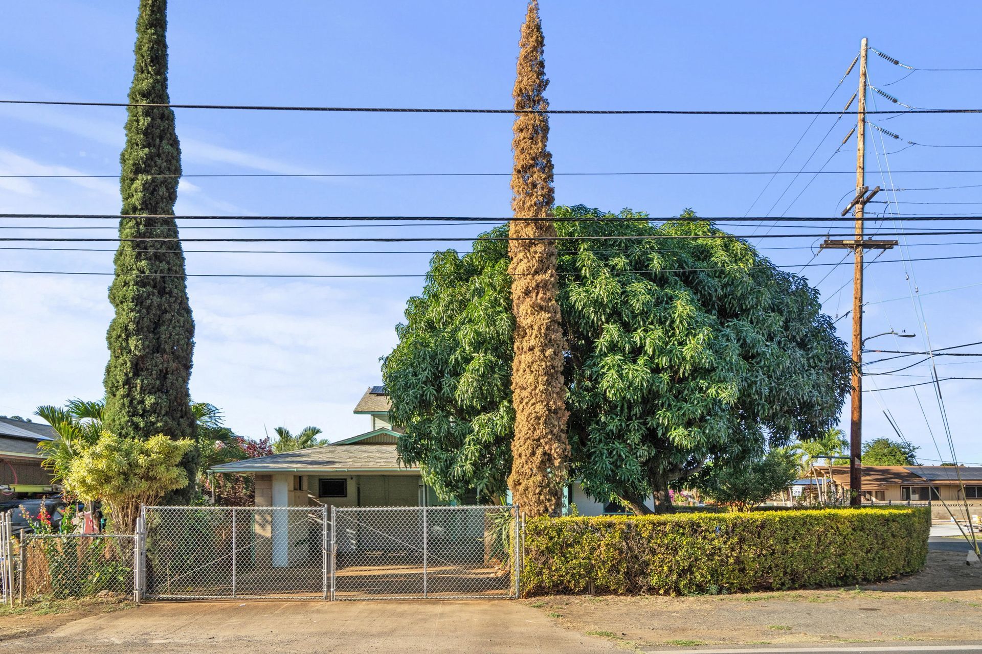 A house with a fence and trees in front of it