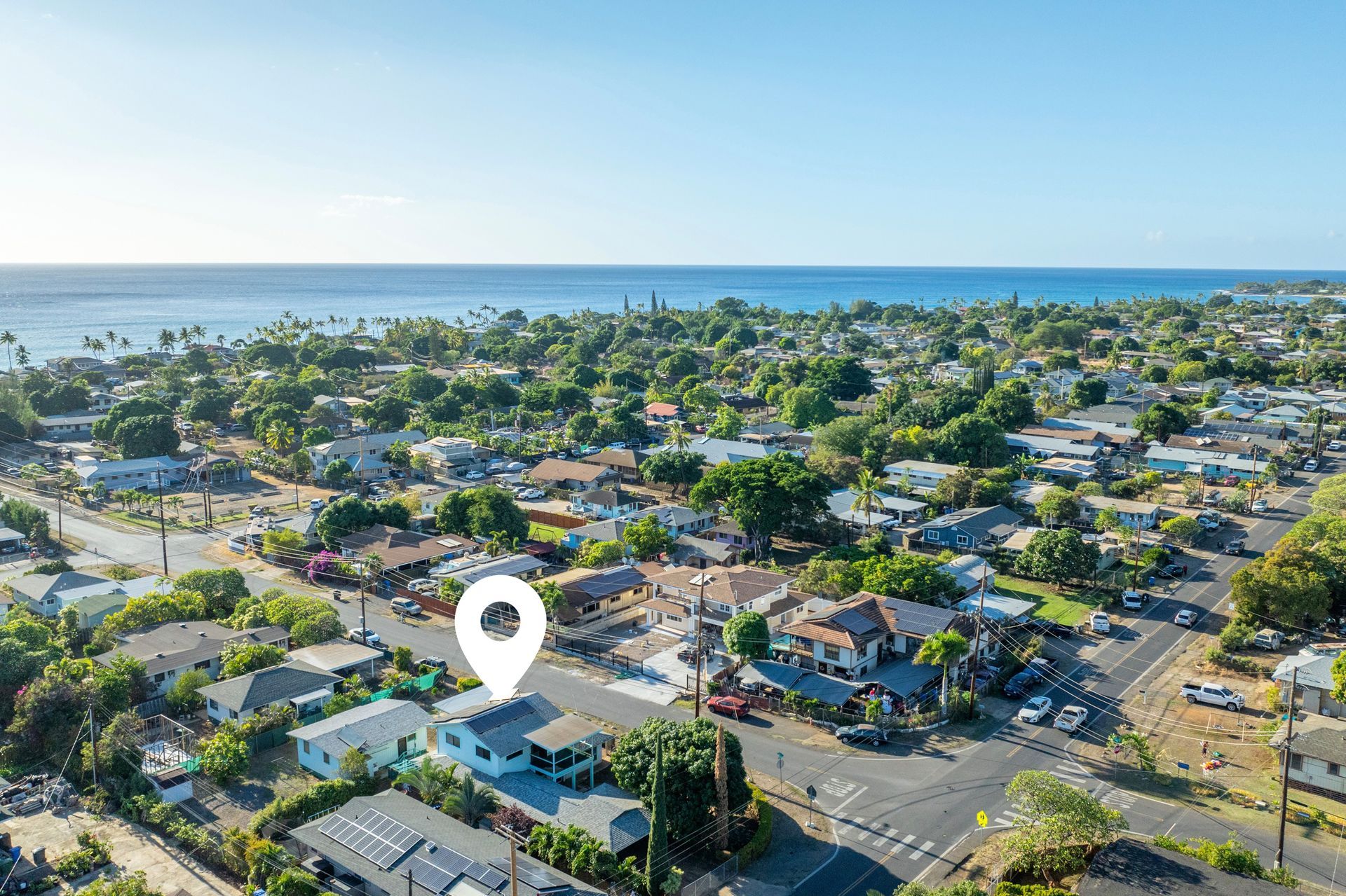 An aerial view of a residential area with a pin pointing the location of a house.