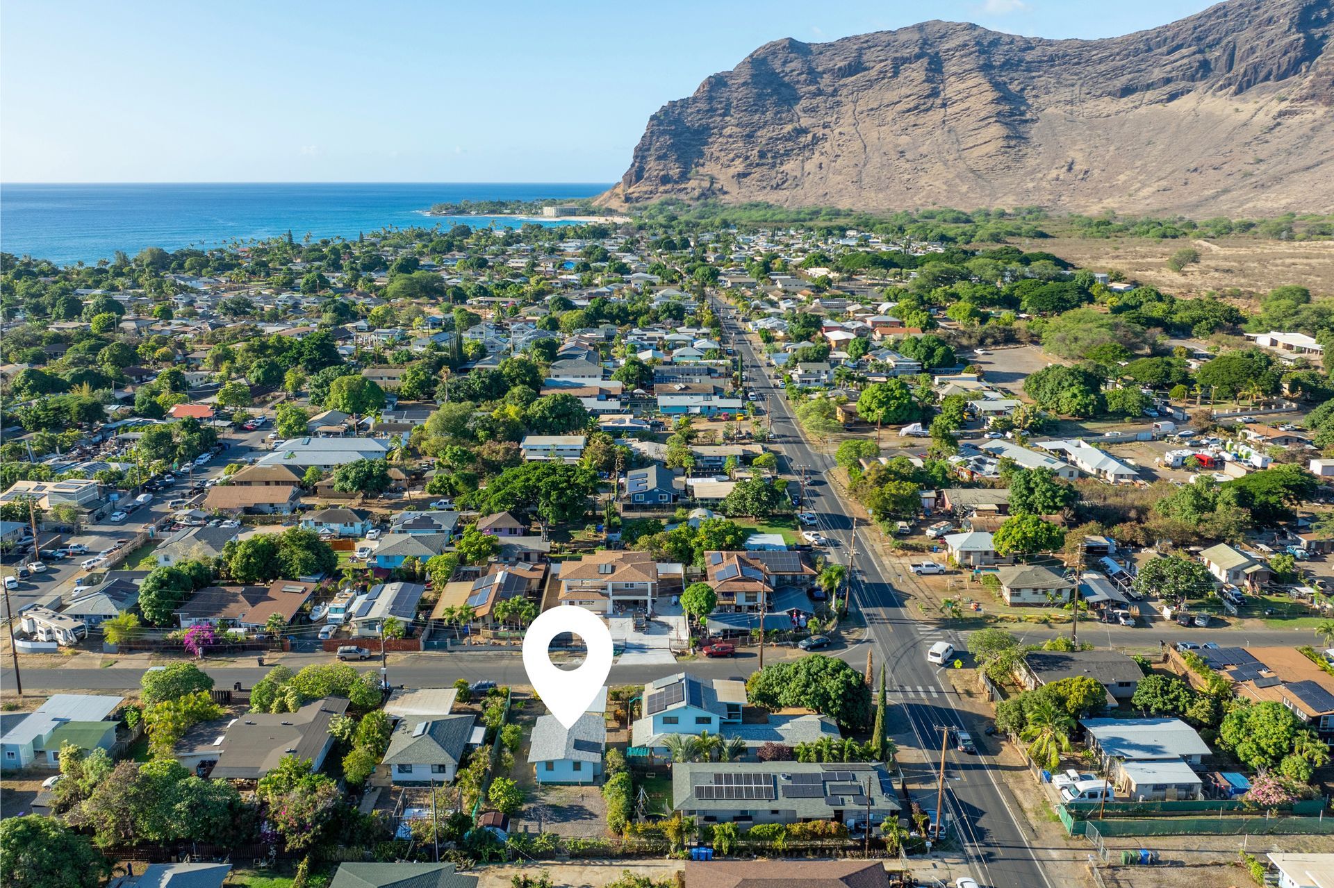 An aerial view of a residential area with a pin pointing the location of a house.