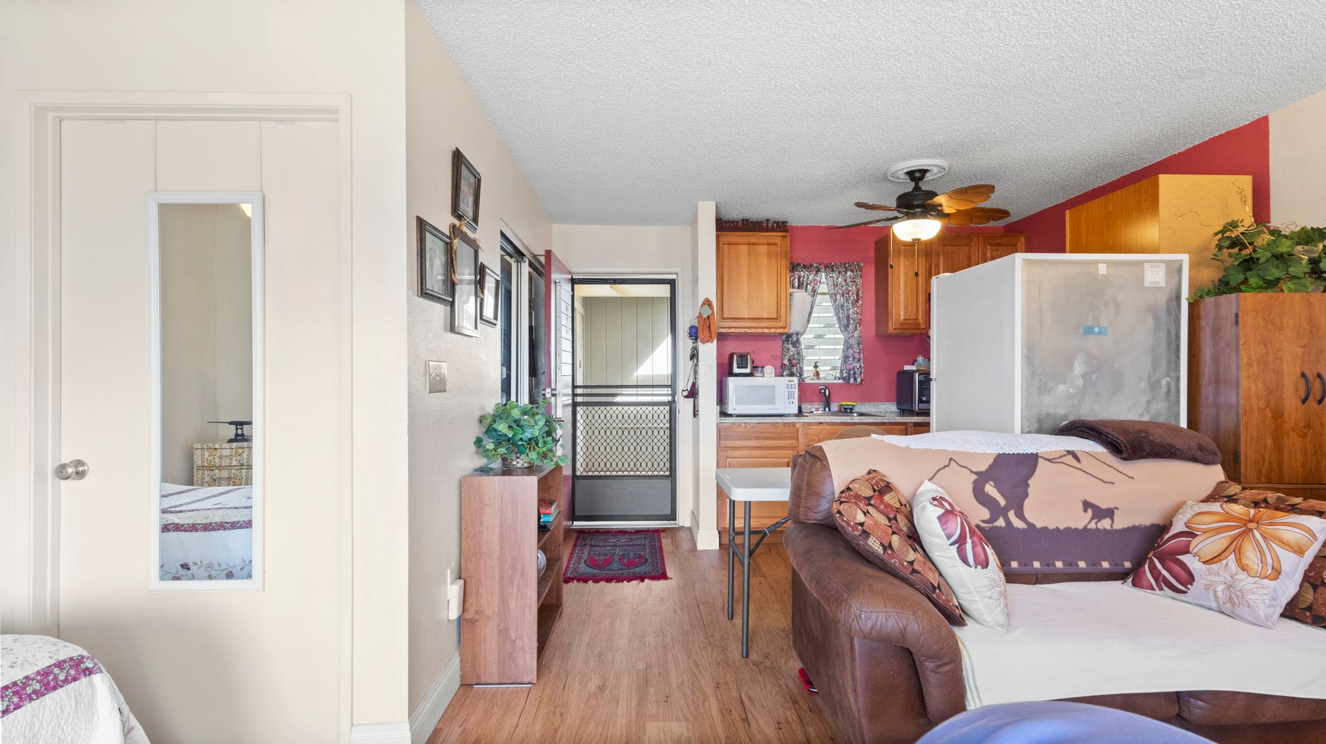 A living room with a couch , chairs , and a ceiling fan.