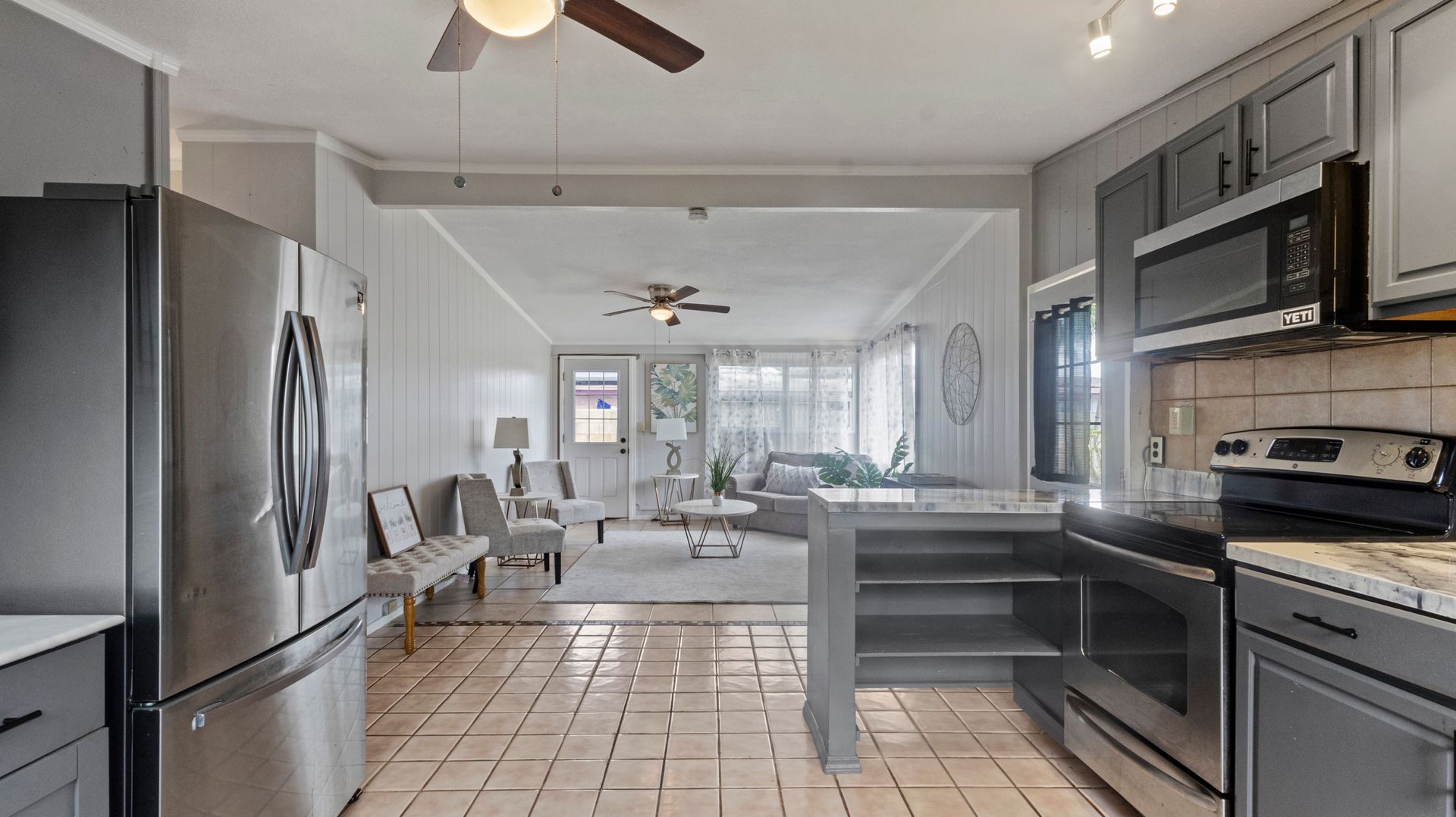 A kitchen with stainless steel appliances and a ceiling fan.