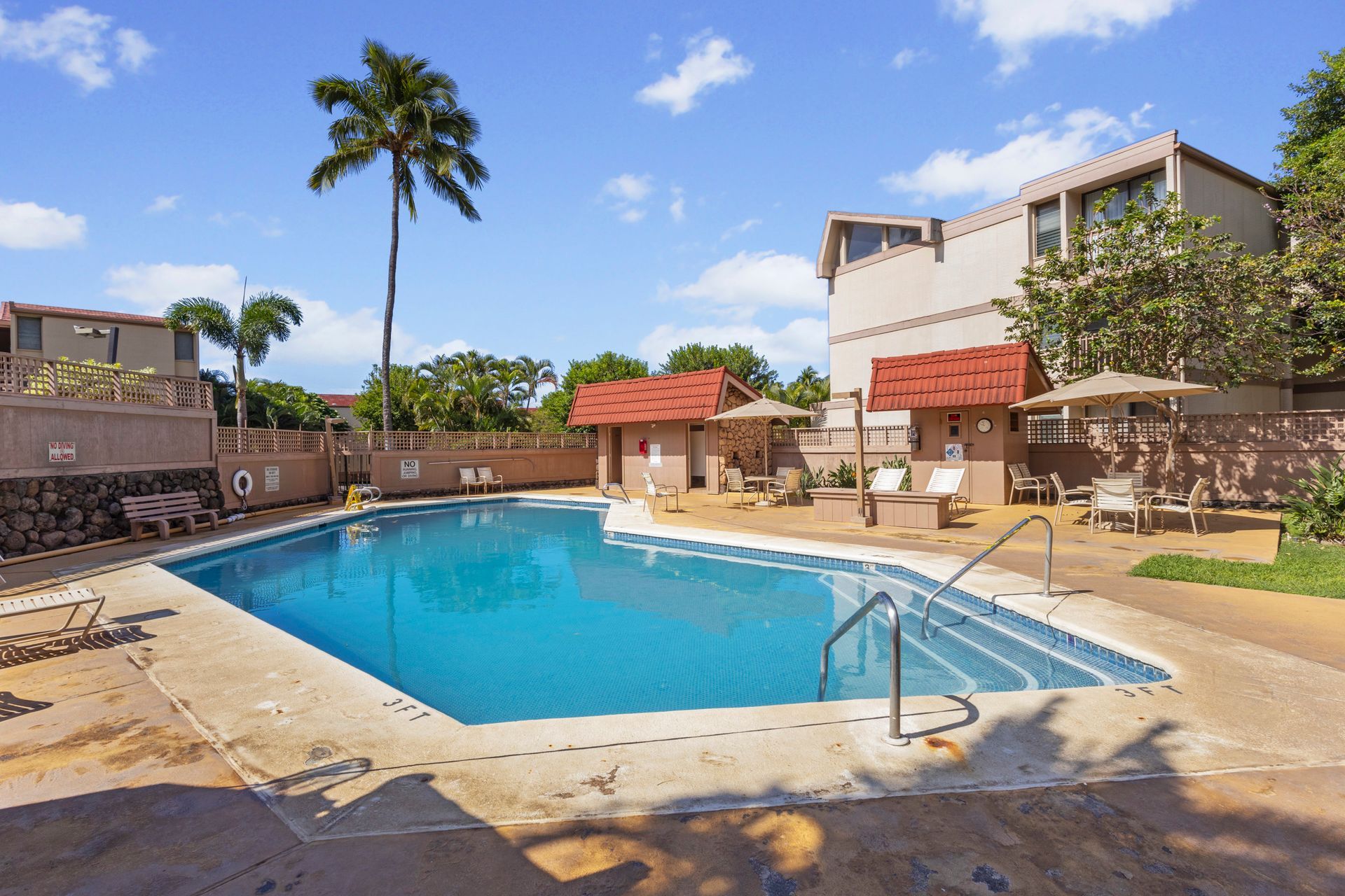 There is a large swimming pool in the middle of a residential area.