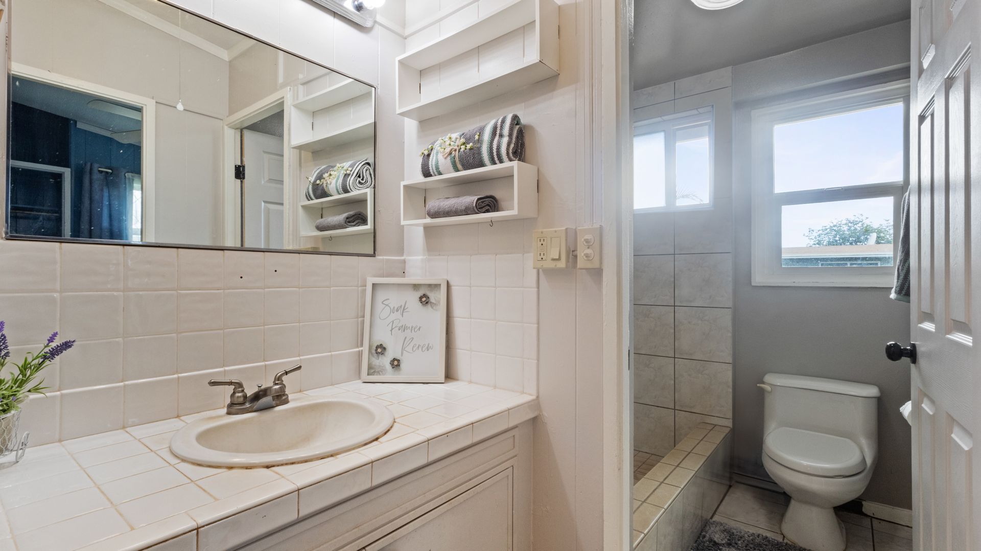 A bathroom with a sink , toilet and mirror.