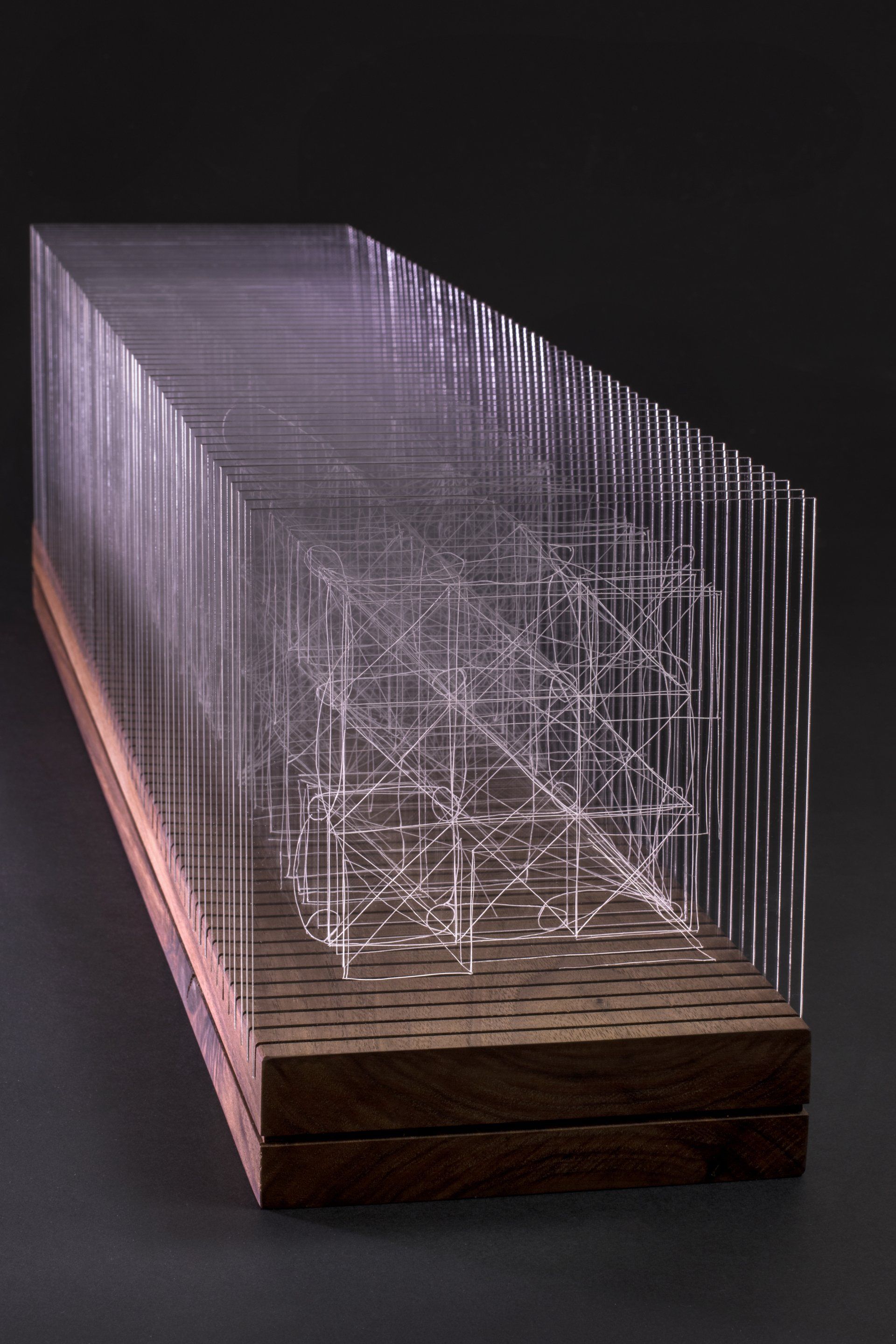 left side view of Connection sculpture, 60 pieces of acrylic engraved on both sides mounted in an oiled walnut base