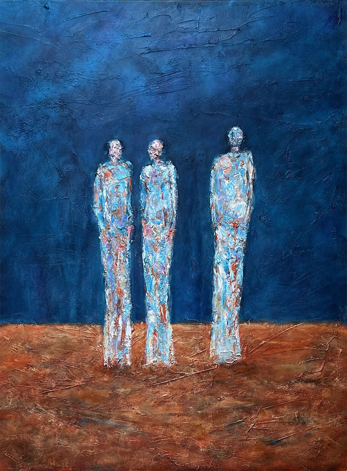 Textured figurative painting with three tall, abstracted figures standing side by side. The background is a deep blue, the ground a rough, earthy red. Each figure appears worn, luminous, and emotionally distinct.