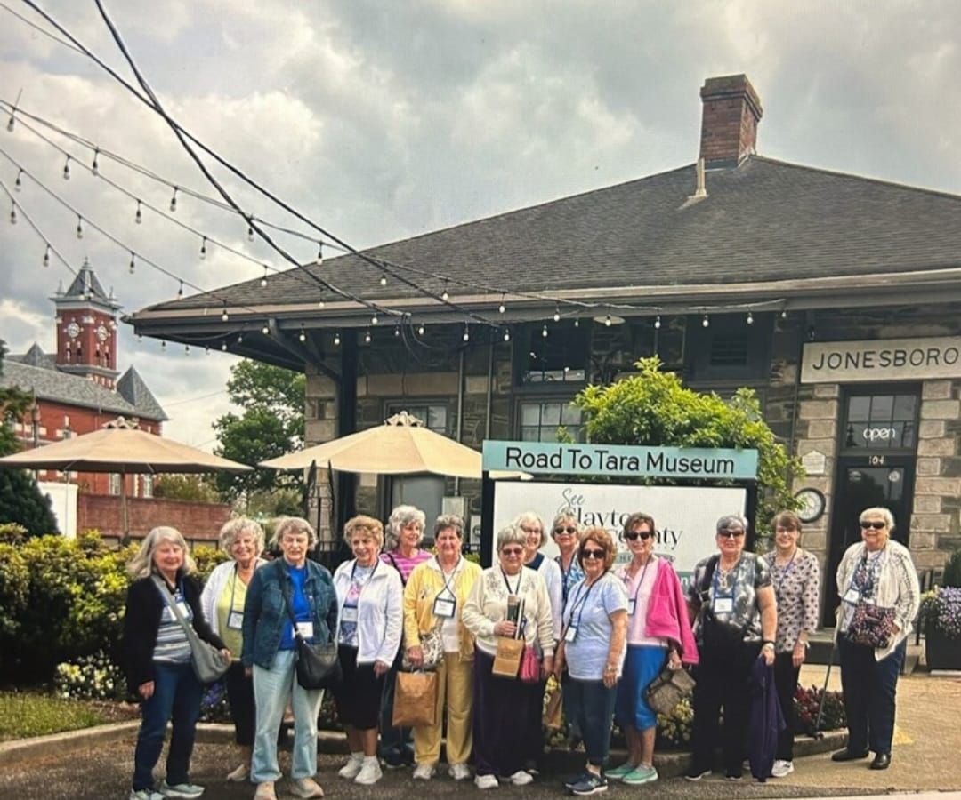 Group of people posing in front of the Road to Tara Museum in Jonesboro, Georgia, under an overcast sky.