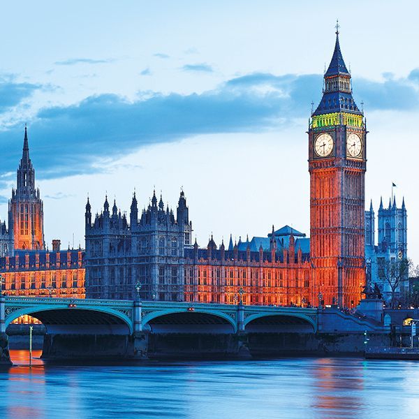 The big ben clock tower in london is lit up at night.