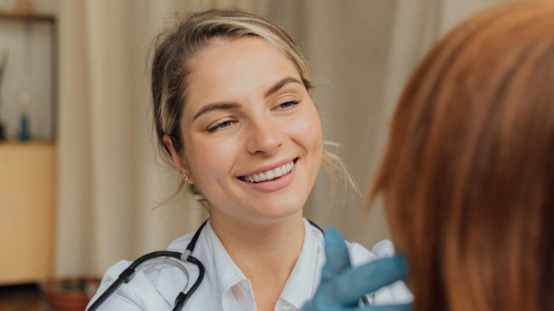 A female doctor is smiling while talking to a patient.