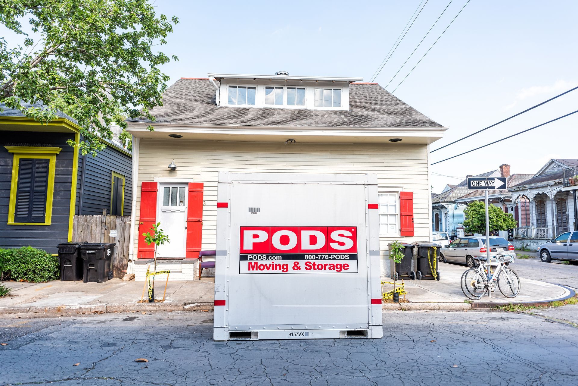 A pods moving and storage trailer is parked in front of a house.