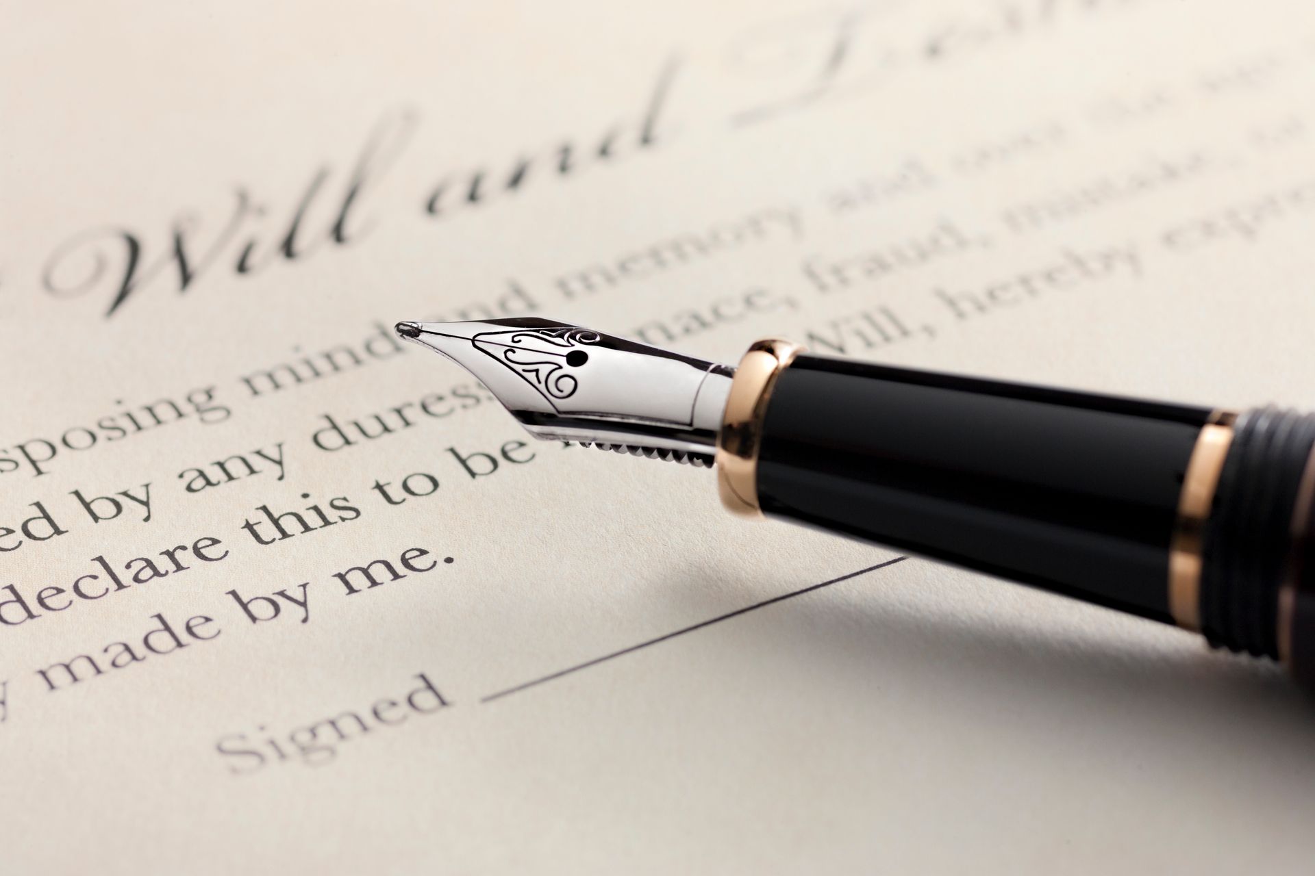 A fountain pen is sitting on top of a will and testament.