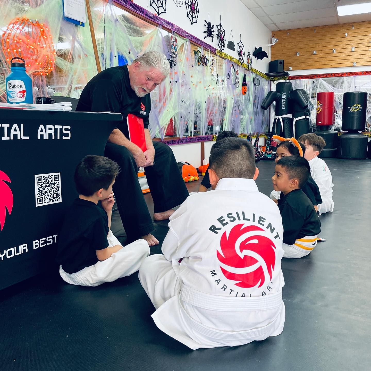 A group of young girls are practicing karate in a gym.