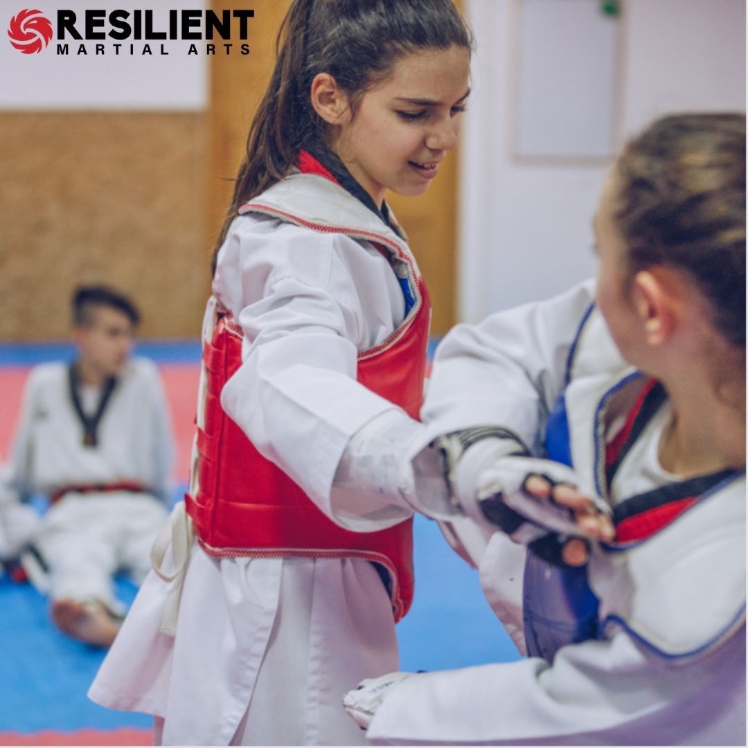 A boy and a girl are practicing taekwondo together.