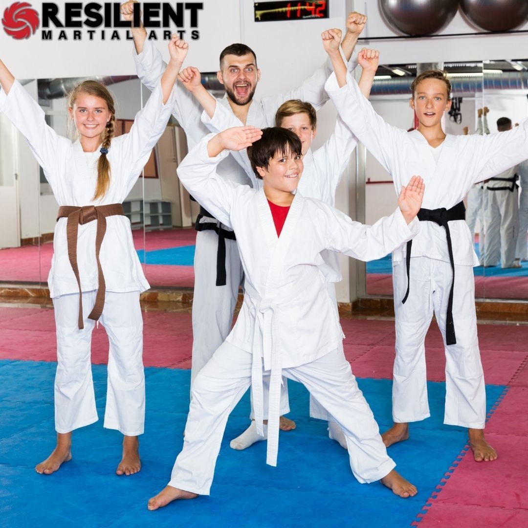 A group of men are practicing karate in a gym.