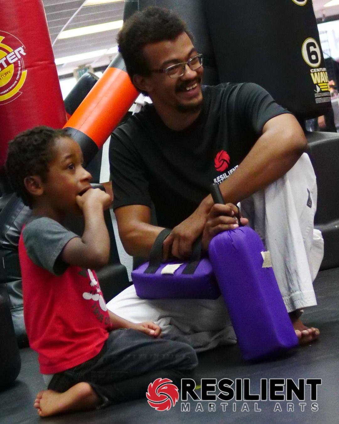 A man and a woman are practicing karate in a gym.