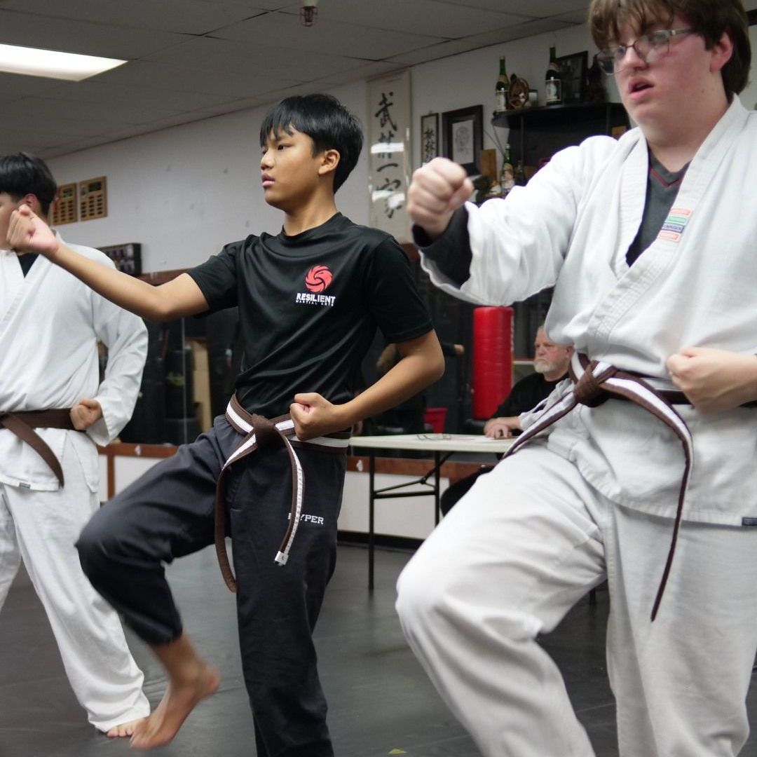 A group of men are practicing karate in a gym.
