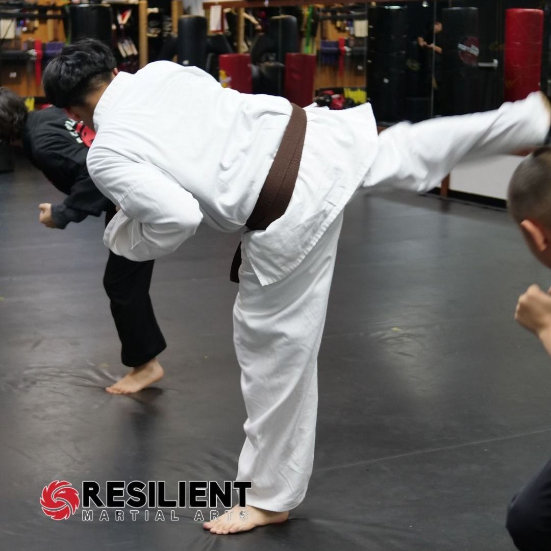 A group of men are practicing karate in a gym.