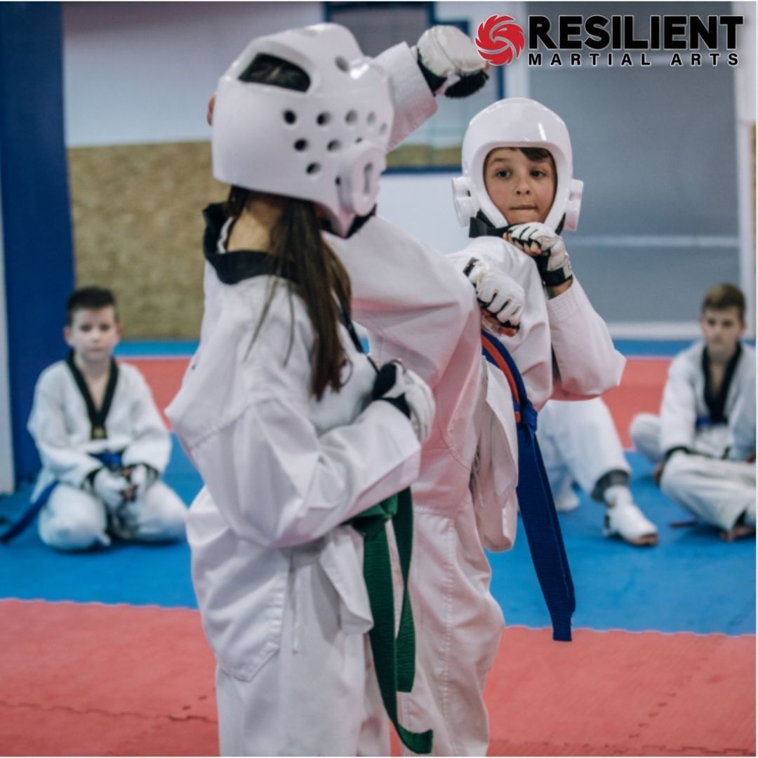 Two young men are practicing karate on a mat
