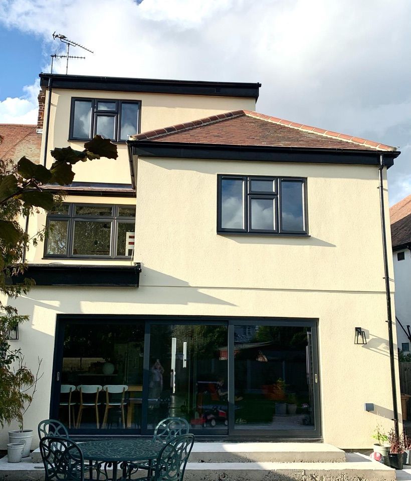 the back of a house with a table and chairs in front of it
