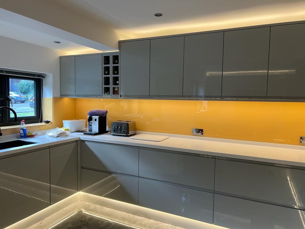 a kitchen with gray cabinets and a yellow backsplash .