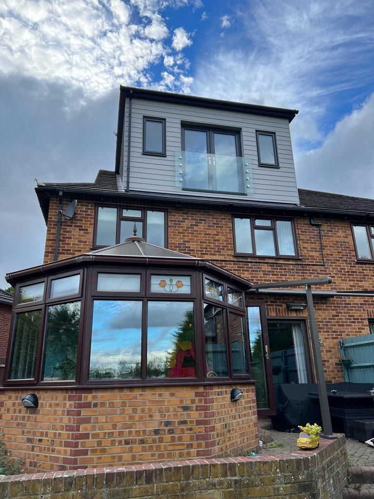 the back of a brick house with a conservatory and a balcony .