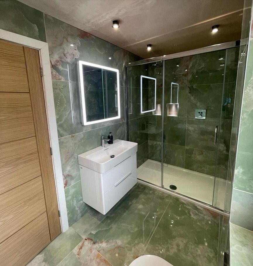 a bathroom with a sink , toilet , shower and mirror .
