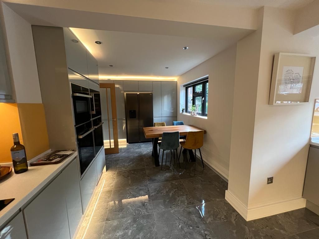 a kitchen with a table and chairs and a refrigerator .