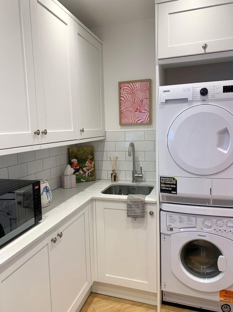 a kitchen with a washer and dryer stacked on top of each other .