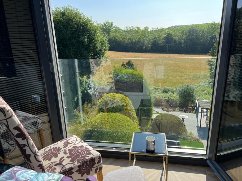 a chair is sitting in front of a window with a view of a field .
