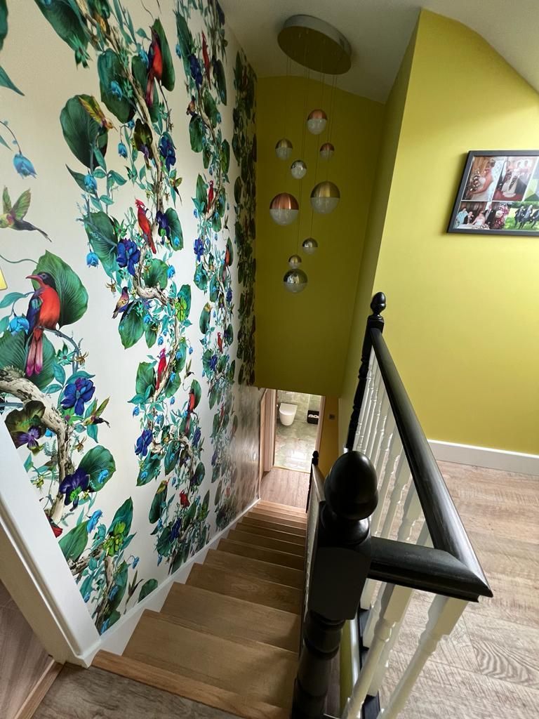 a staircase with a floral wallpaper on the wall and a picture on the wall .