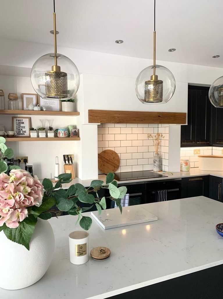 a kitchen with a vase of flowers and a candle on the counter .